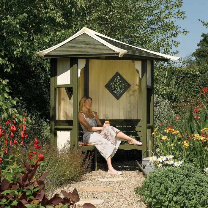 Haven Wooden Three Seater Corner Arbour with Green and White Detailing by Rowlinson® - 2.5m 1 Haven Wooden Three Seater Corner Arbour with Green and White Detailing by Rowlinson® - 2.5m